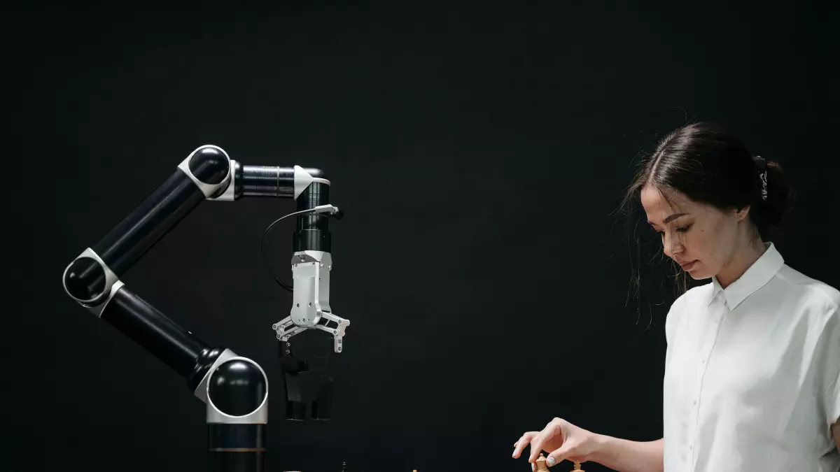 A woman plays chess against a robotic arm.