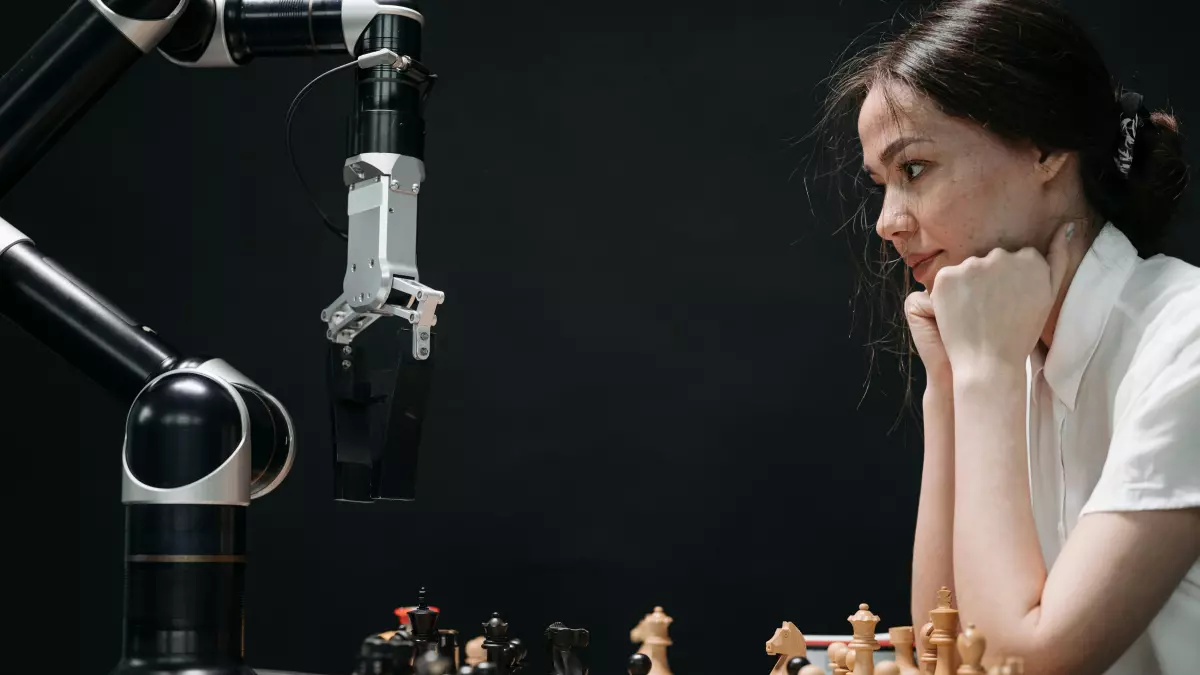 A close-up shot of a humanoid robot arm playing chess against a human opponent.