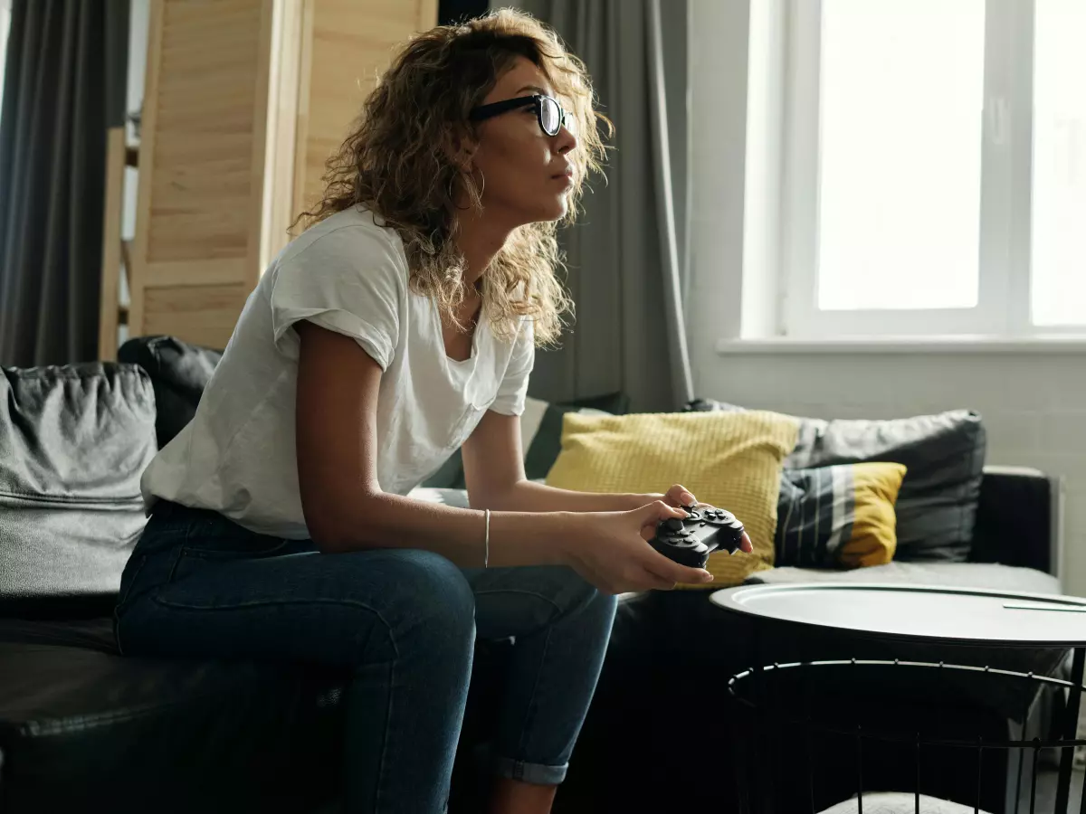 A woman playing a video game on a couch