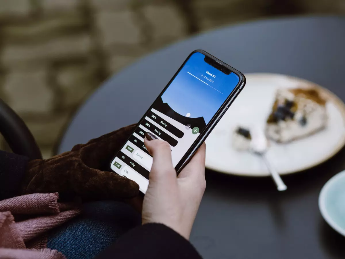 A hand using a smartphone with a bright blue and white screen