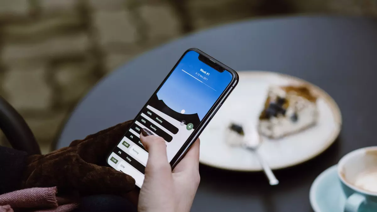 A hand using a smartphone with a bright blue and white screen