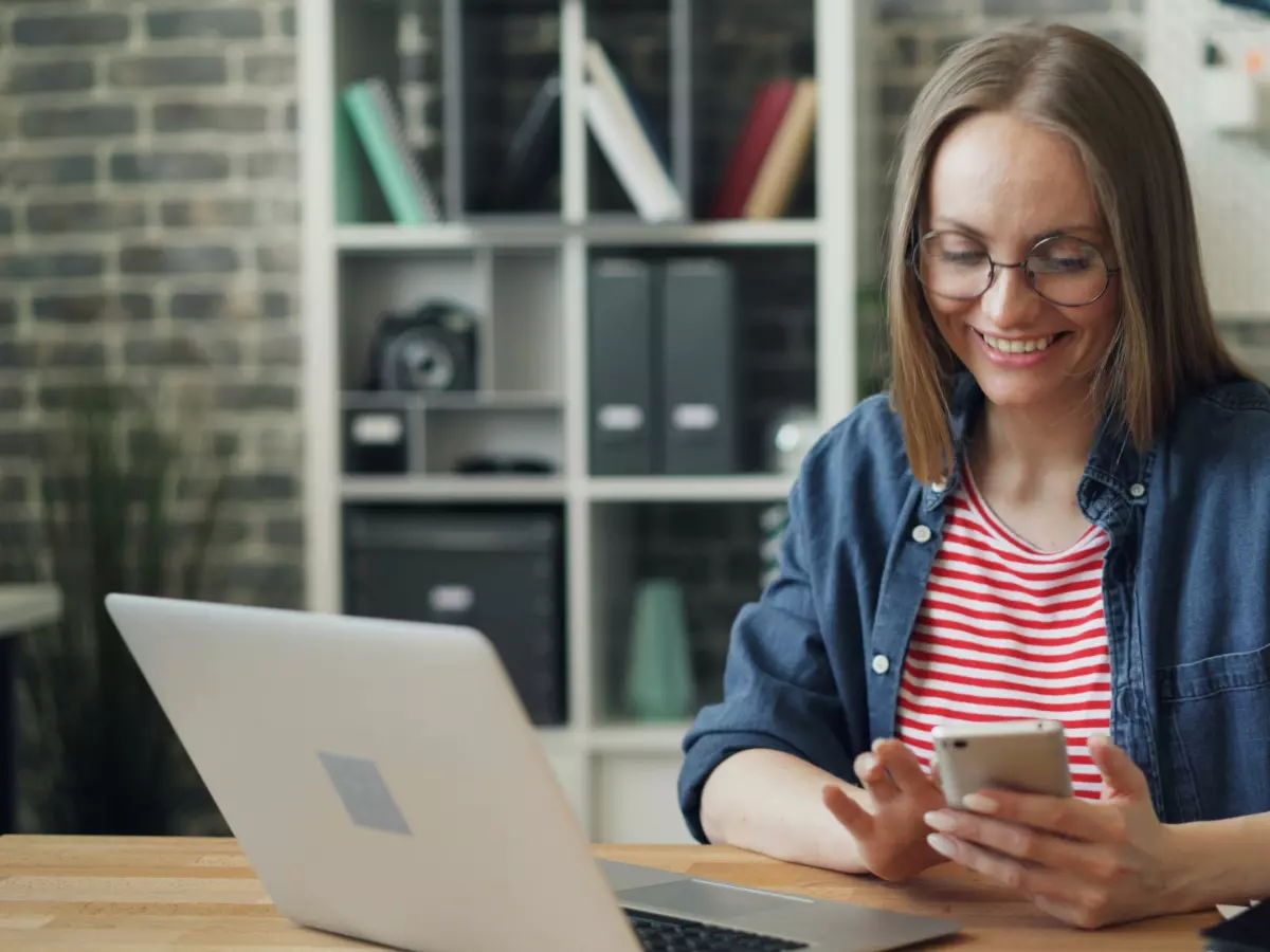 Three women are looking at a smartphone.