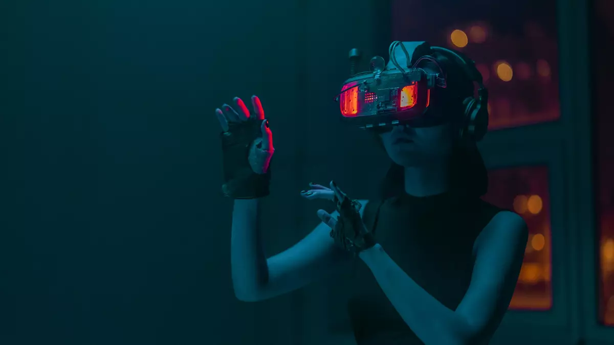 A woman wearing VR goggles, with red LED lights illuminating her face, holds out her hands in a gesture of wonder or surprise.