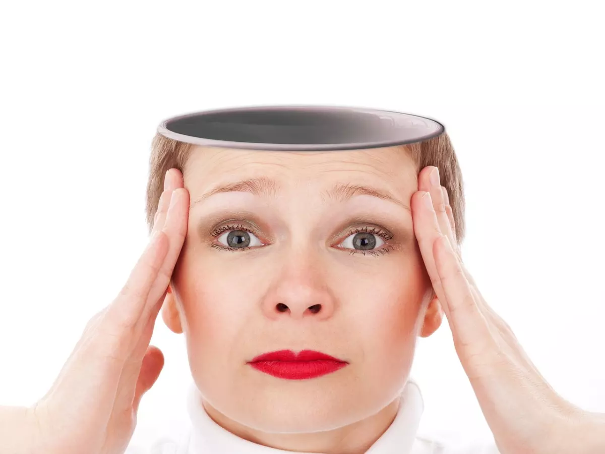 A woman with her hands on her head, looking worried.