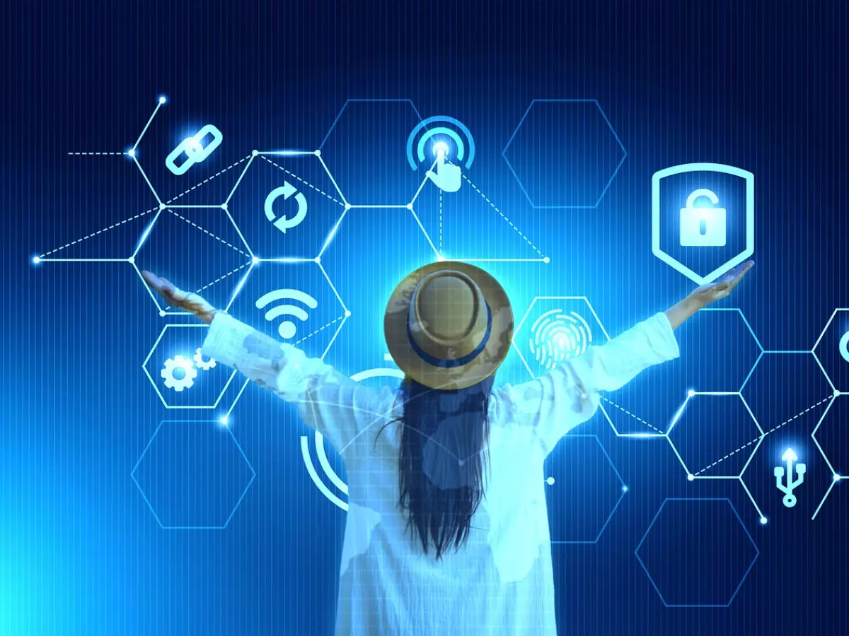 A woman wearing a white shirt and a hat, standing with her arms outstretched in front of a blue futuristic background, with a series of hexagonal graphic symbols of data security. 