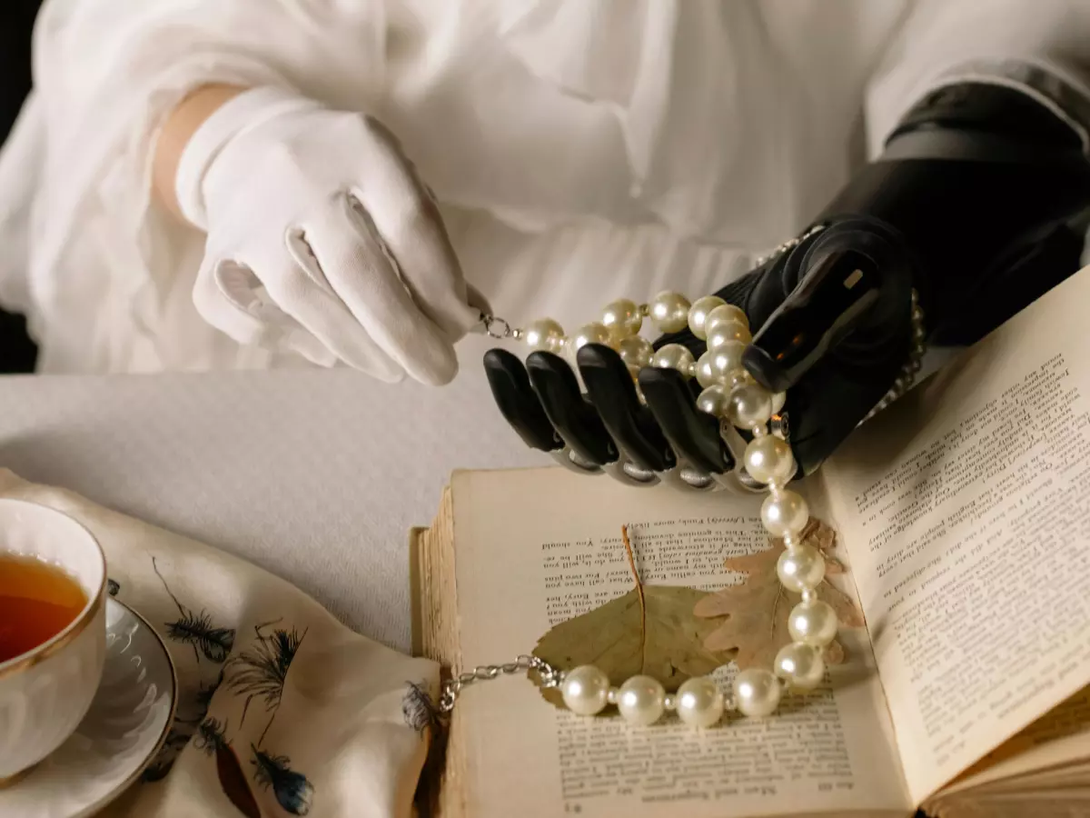 A robotic hand is shown holding a string of pearls.