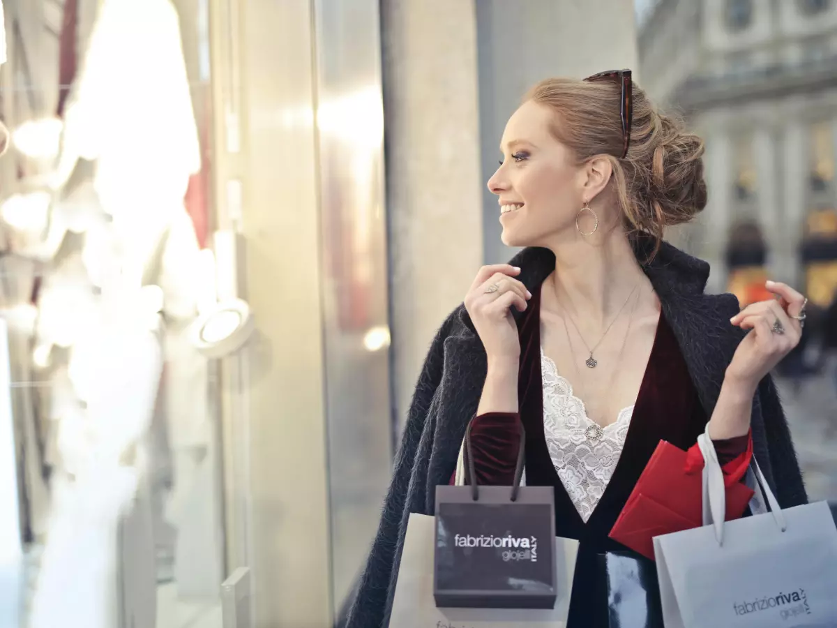 A woman in a store holding a pair of silver sparkly heels