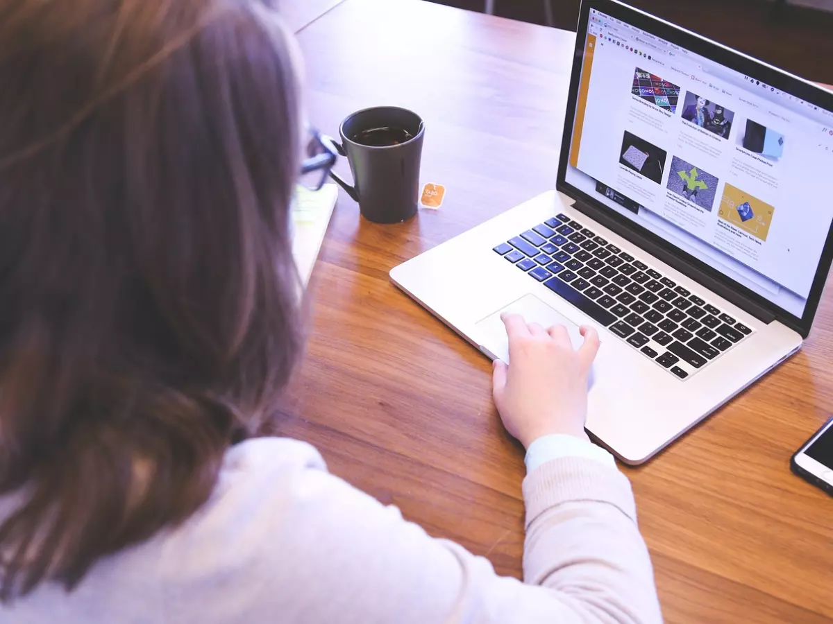 A woman working on a laptop at a desk.