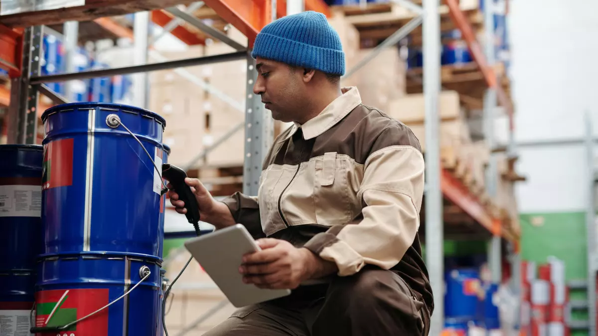 A man in a warehouse setting checking inventory on a tablet.