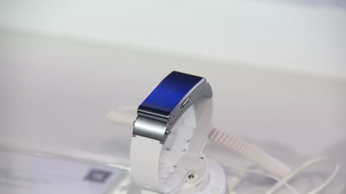 A white and silver smartwatch on a white stand.