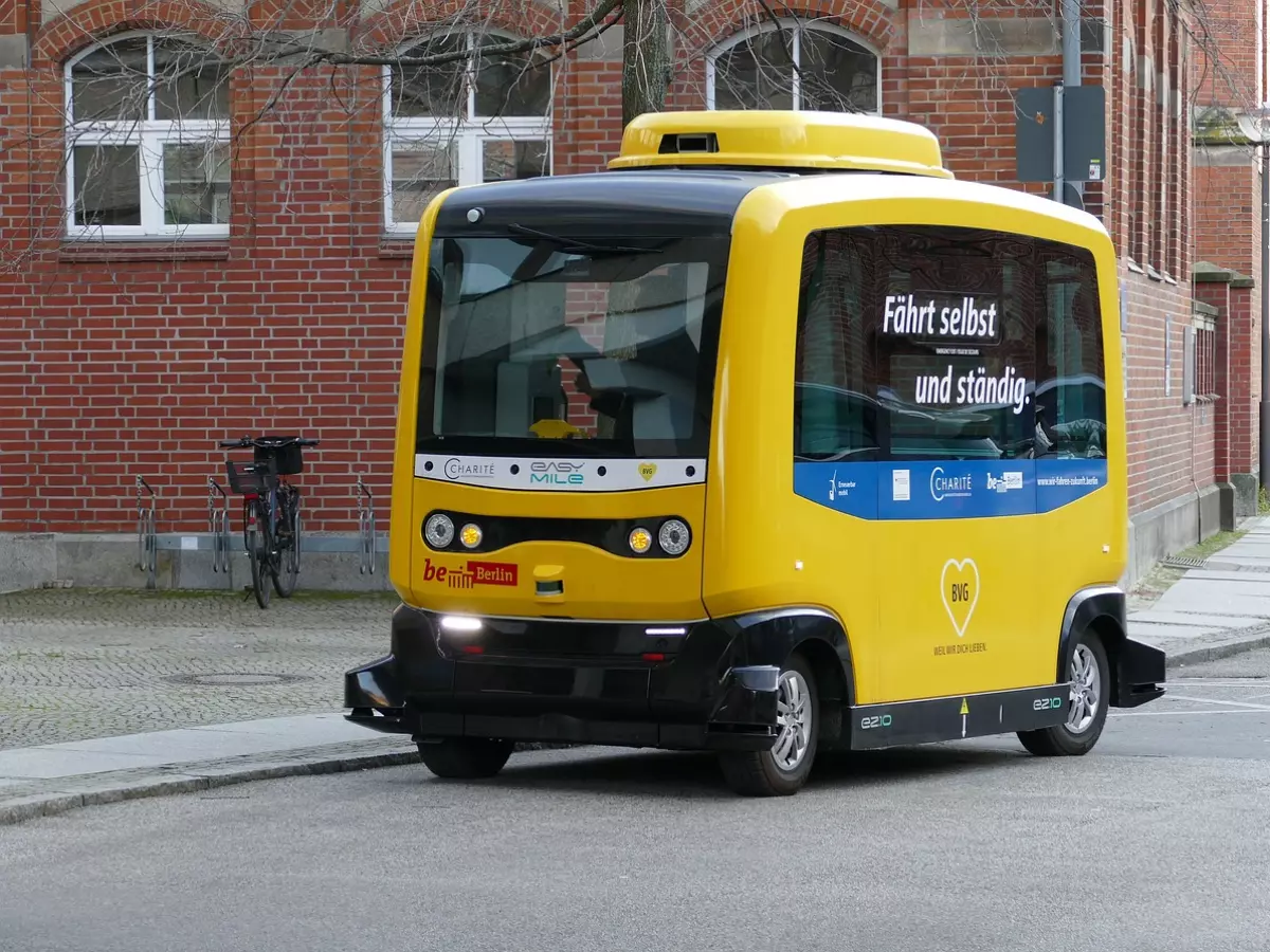 An autonomous yellow bus driving on a city street